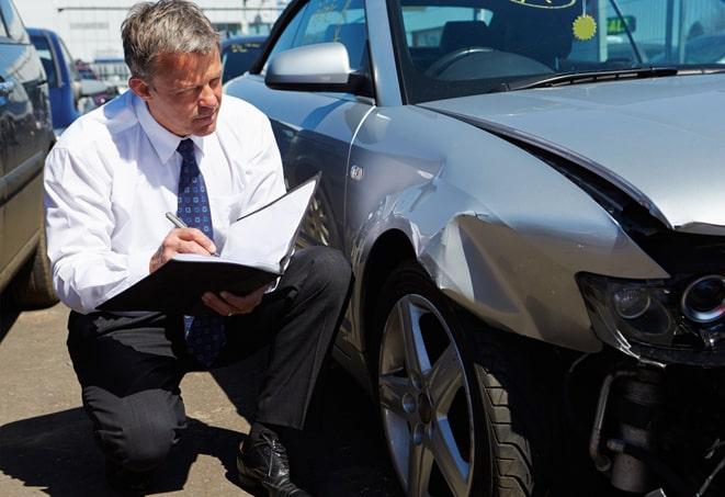 a car insurance policy document being signed at an office desk